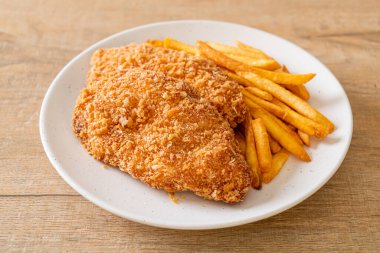 Kızarmış tavuk göğsü fileto biftek yanında patates kızartması ve ketçap.