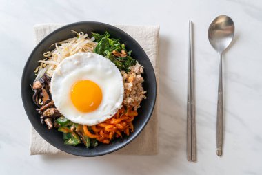 Bibimbap, Kore baharatlı salata pilav ve sahanda yumurta. Geleneksel Kore yemeği tarzı.