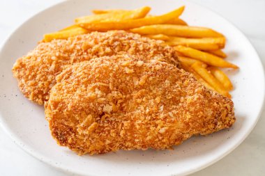 Kızarmış tavuk göğsü fileto biftek yanında patates kızartması ve ketçap.