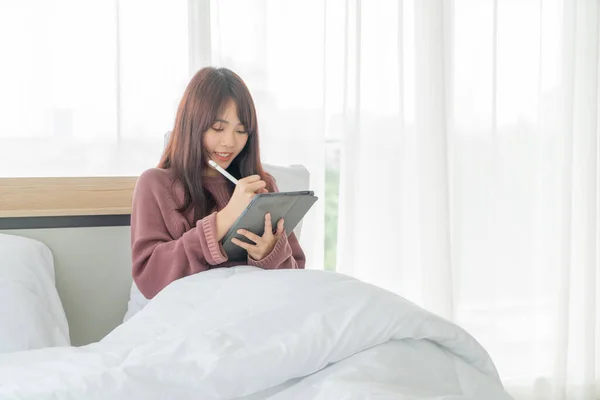 正在床上做平板电脑的漂亮的亚洲女人 — 图库照片
