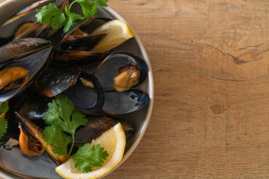 Limonlu bir kasede otlu taze midyeler.