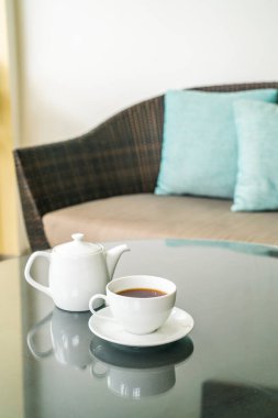 Masada çaydanlık olan beyaz çay fincanı