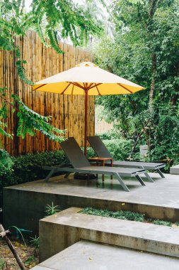 Otelin havuzunda havuz çevresinde şemsiye ve bilardo takımı.