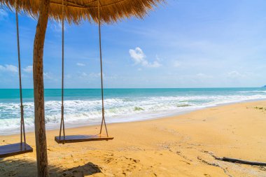 Okyanus denizi ve mavi gökyüzü arka planıyla sahilde sallan