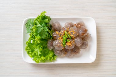 Şeffaf toplara Saku Sai Moo ya da buharda pişirilmiş Tapioca köfteleri deniyor.