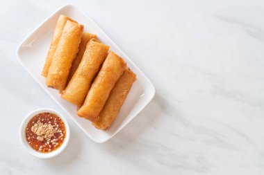 Kızarmış yumurta rulosu ve beyaz tabakta sos.