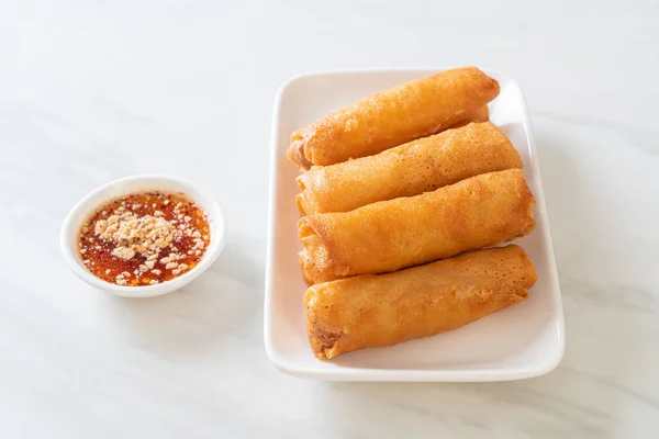 deep fried spring roll with sauce on white plate