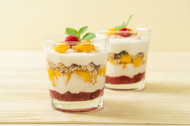 Ev yapımı taze mango ve yoğurt ve granola ile taze ahududu. Sağlıklı yemek tarzı.