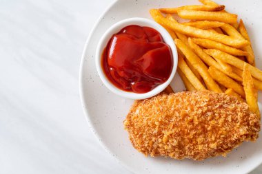 Kızarmış tavuk göğsü fileto biftek yanında patates kızartması ve ketçap.