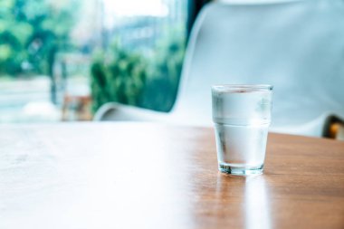 Ahşap masada bir bardak su.