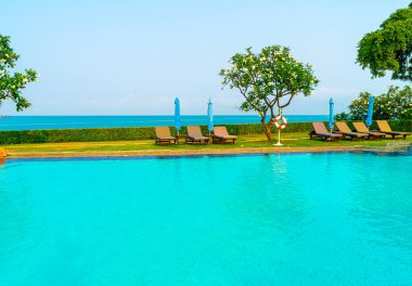 Havuz kenarındaki havuz, havuz, şemsiye, deniz manzaralı havuz tatilleri ve tatil konsepti.