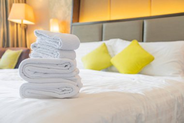 Otel odasında beyaz havlu katlanır.