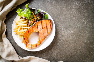 Kızarmış somon bifteği fileto, sebze ve patates kızartması.