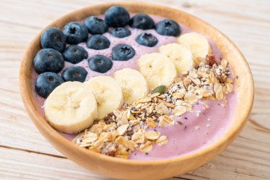 Yoğurt ya da yoğurtlu smoothie kasesi, böğürtlen, muz ve granola.