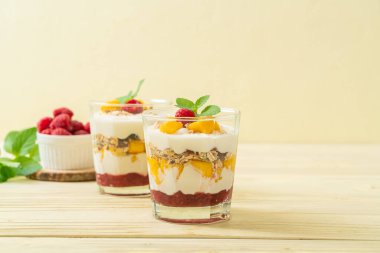 Ev yapımı taze mango ve yoğurt ve granola ile taze ahududu. Sağlıklı yemek tarzı.