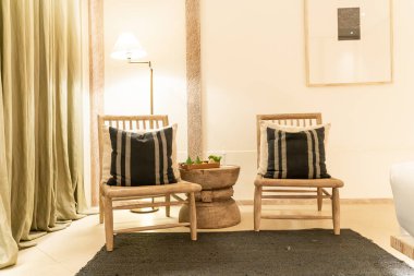 Lüks otel dinlenme odası ve yatak odasında beyaz yastıklar koltukta süslenir.