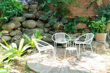 Bahçedeki boş beyaz sandalye.