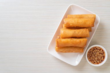 Kızarmış yumurta rulosu ve beyaz tabakta sos.