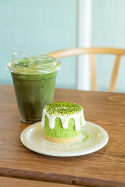 Kafe restoranındaki yeşil çay fincanlı kibrit yeşil çay peynirli kek.