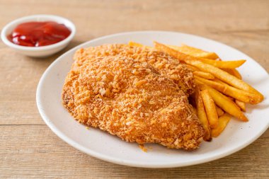 Kızarmış tavuk göğsü fileto biftek yanında patates kızartması ve ketçap.