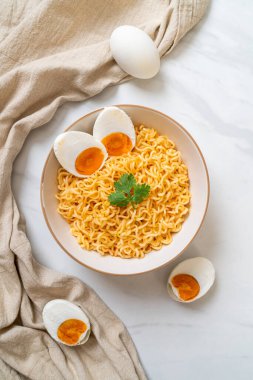 Hazır erişte kasesi ve tuzlu yumurta.