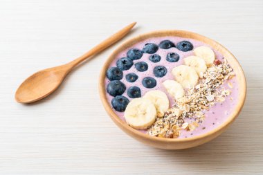 Yoğurt ya da yoğurtlu smoothie kasesi, böğürtlen, muz ve granola.