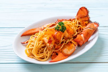 Beyaz tabakta karides yumurtalı ıstakoz spagettisi.