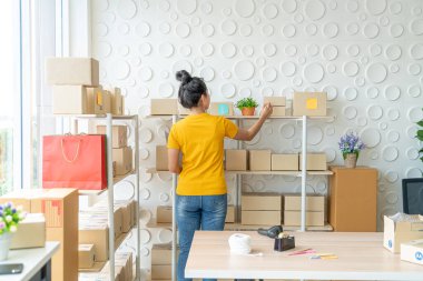 Genç Asyalı kadın depodaki stokları kontrol ediyor - çevrimiçi satış veya online alışveriş kavramı