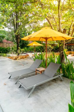 Otelin havuzunda havuz çevresinde şemsiye ve bilardo takımı.