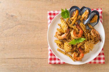 Deniz ürünleri ve fesleğen soslu kızarmış spiral makarna. Füzyon yemek tarzı.