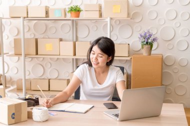 Genç Asyalı kadın, işyerinde dijital tabletle çalışan küçük bir işletme sahibi kuruyor - İnternet satışı, e-ticaret, nakliye konsepti