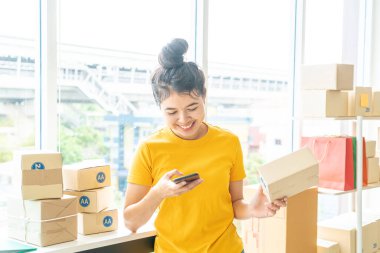 İş yerinde paketleme kutusuyla çalışan Asyalı Kadın işyeri sahibi - çevrimiçi alışveriş KOBİ girişimcisi veya serbest çalışma konsepti