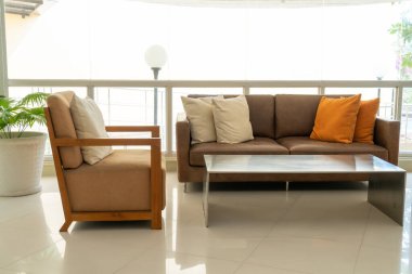 Boş kanepe ve yastıklı sandalye bir odada.