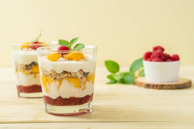 Ev yapımı taze mango ve yoğurt ve granola ile taze ahududu. Sağlıklı yemek tarzı.