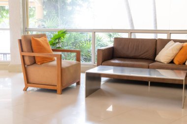 Boş kanepe ve yastıklı sandalye bir odada.