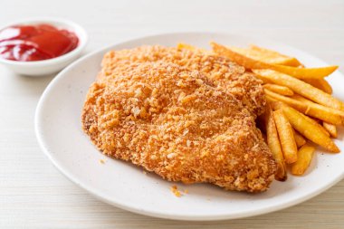 Kızarmış tavuk göğsü fileto biftek yanında patates kızartması ve ketçap.