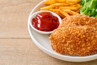 Kızarmış tavuk göğsü fileto biftek yanında patates kızartması ve ketçap.