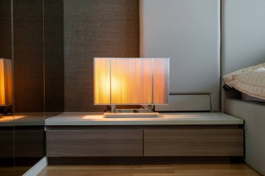 Yatak odasındaki dekorasyonun yanında güzel bir lamba.