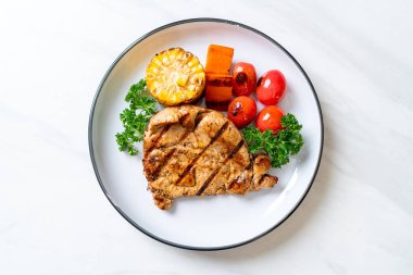 Izgara ve ızgara fileto domuz bifteği, mısır, havuç ve domates.