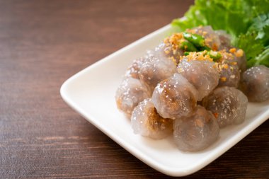 Şeffaf toplara Saku Sai Moo ya da buharda pişirilmiş Tapioca köfteleri deniyor.