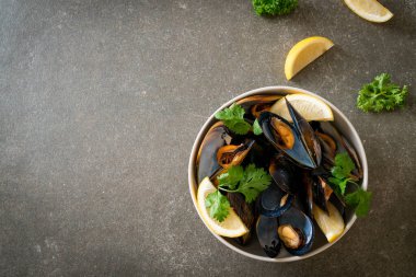 Limonlu bir kasede otlu taze midyeler.