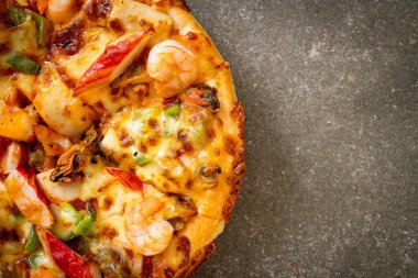 Tahta tepside deniz ürünleri (karides, ahtapot, midye ve yengeç) pizza