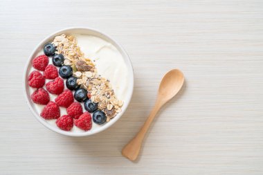 Ev yapımı yoğurt kasesi, ahududu, yaban mersini ve granola. Sağlıklı yemek tarzı.