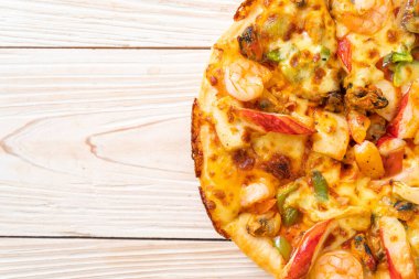 Tahta tepside deniz ürünleri (karides, ahtapot, midye ve yengeç) pizza