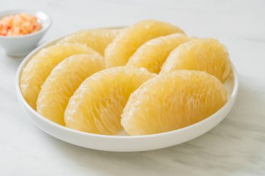 Taze soyulmuş zeytin, greyfurt ya da beyaz tabakta Shaddock.