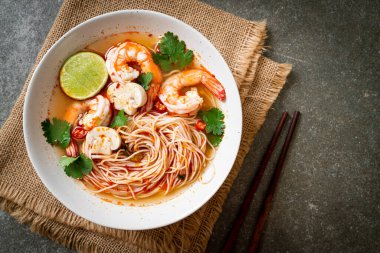 Baharatlı erişte çorbası ve beyaz kasede karides (Tom Yum Kung) - Asya yemeği tarzı