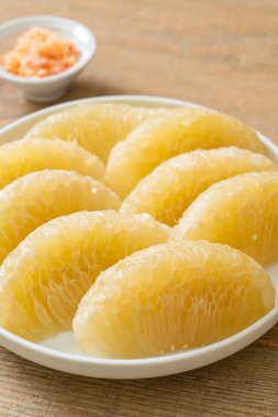 Taze soyulmuş zeytin, greyfurt ya da beyaz tabakta Shaddock.