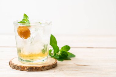 Sodayla buzlu erik suyu ve ahşap masada nane şekeri - içecek.