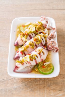 Baharatlı biber ve limon soslu haşlanmış mürekkep balığı veya ahtapot.