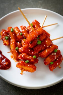 deep fried Korean rice cake (Tteokbokki) skewered with spicy sauce - Korean food style clipart